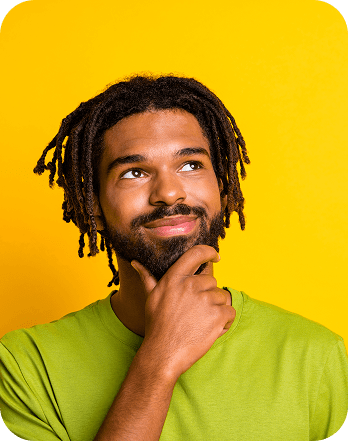 Man in a green shirt smiling thoughtfully against a bright yellow background, suggesting creative ideas and innovation with Trademarkhost trademark services.